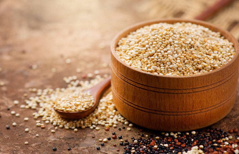 quinoa en pocillo de madera sobre mesón oscuro