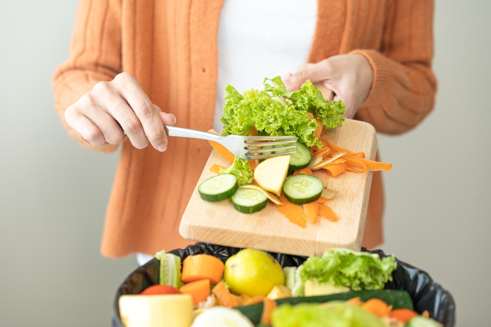 desperdicio de alimentos en chile mujer botando restos de verduras al basurero