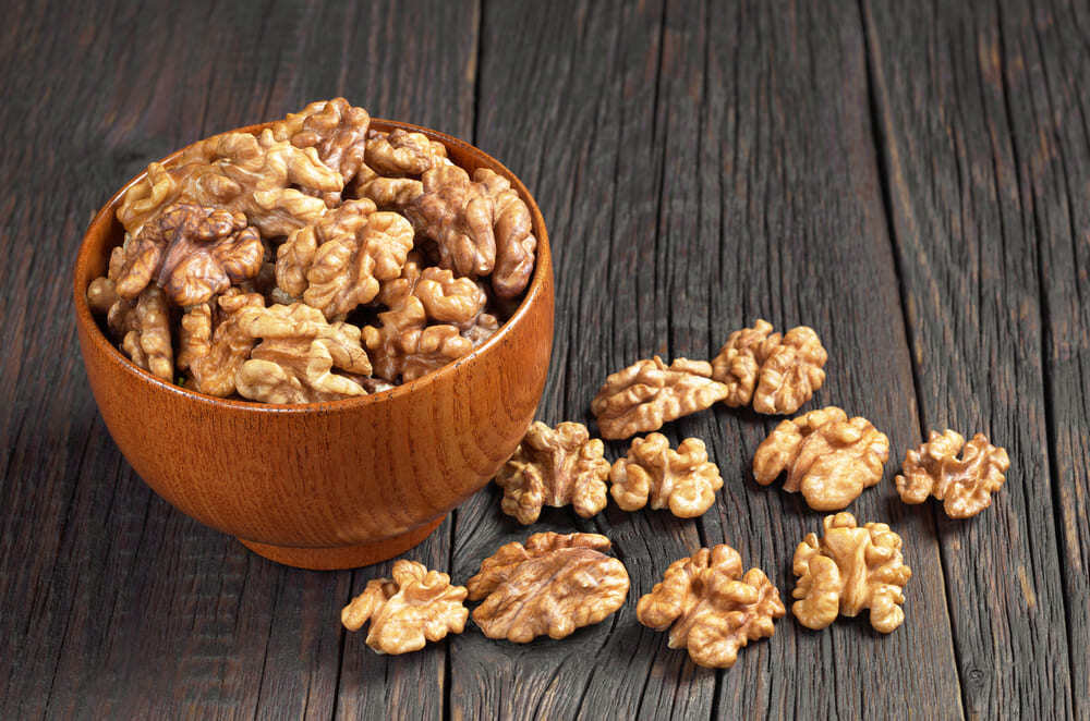 nueces sin cáscara en recipiente de madera 